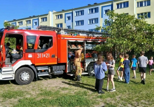 Policjanci, motocykl i samochód policyjny podczas pikniku w Szkole Podstawowej nr 137
