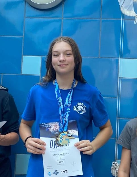 Uczennica klasy 8a powołana do Kadry Narodowej Juniora Młodszego w pływaniu w sezonie 2022/2022 Na zdjęciu z medalem i dyplomem za osiągnięcia sportowe