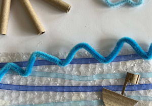 Asamblaż z materiałów papierowych, folii i tkanin nawiązujący do morskiego pejzażu