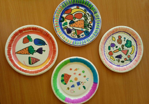 Przykładowe prace uczniów przedstawiające papierowe talerze z rysunkami owoców i warzyw