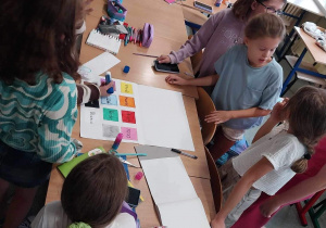 Uczniowie klasy 4c pracują nad projektem przygotowując plakaty zawierające tłumaczenie kolorów w języku hiszpańskim i włoskim