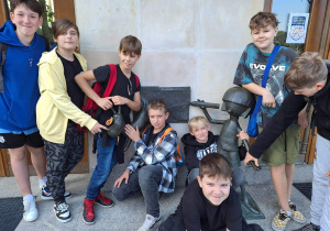 Grupa uczniów przy pomniku bohaterów Zaczarowanego Ołówka znajdującego się na szlaku Łódź Bajkowa, studia Se-ma-for.