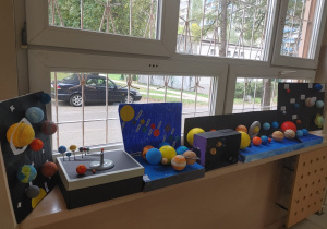 Prace przestrzenne uczniów klas szóstych przedstawiające modele Układu Słonecznego wykonane na zajęciach geografii.