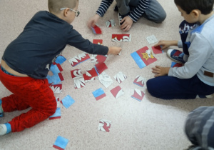 Uczniowie układają puzzle z wizerunkiem Orła Białego