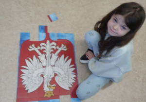 Uczennica układa puzzle z wizerunkiem Orła Białego