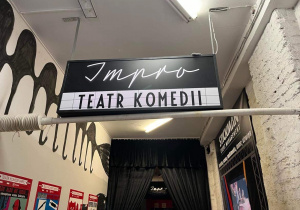 Wejście do wnętrza Teatru Impro – widok na baner z napisem Teatr Komedii Impro