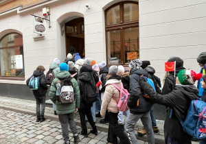 Grupa uczestników wycieczki wchodzi do Muzeum Pyry