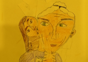 Laurka wykonana przez uczennicę uczęszczającą do świetlicy. Przedstawia kobietę z siwymi włosami o zielonych oczach oraz przytuloną do jej szyi dziewczynkę. Postaci znajdują się na żółtym tle.