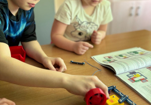 Uczniowie z klas siódmych pomagają przedszkolakom w tworzeniu robota Lego Spike.
