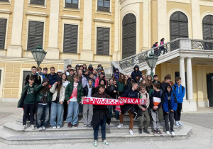 Uczestnicy wycieczki stoją przed Pałacem Schönbrunn, rezydencją Habsburgów