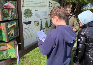 Uczniowie klas czwartych podczas terenowej gry edukacyjnej w Pracowni pod Chmurką – segregowanie odpadów, wyznaczanie kierunków świata, obserwacja pogody, rozpoznawanie ziół.