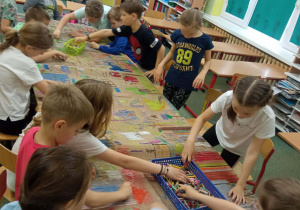 Zajęcia plastyczne w klasie Dzieci rysują na dużych arkuszach papieru.