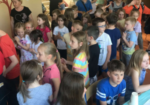 Uczniowie zgromadzeni na korytarzu uczestniczą w zabawach muzycznych