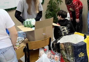 Uczniowie klasy 7a pakują rzeczy dla wybranej rodziny.