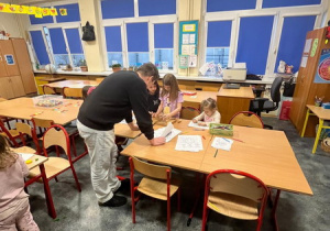 Dzieci i ich rodzice odwiedzają sale lekcyjne.