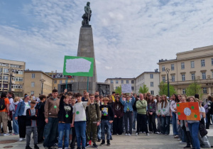 Uczniowie stoją na Placu Wolności z przygotowanymi transparentami i oczekują na rozpoczęcie Marszu.