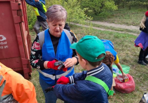 Uczniowie klas czwartych wraz z opiekunami przygotowują się do sprzątania lasu.