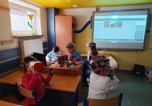 Uczniowie klas młodszych wędrują przy użyciu okularów VR z kropelkami po cyklu wodnym.