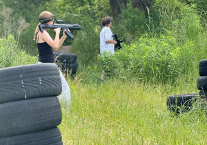 Uczniowie klasy szóstej poruszają się w terenie podczas gry z laserami.