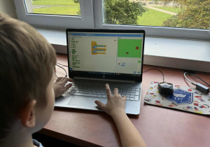 Uczeń programuje grę w programie Scratch Junior.