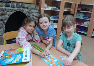 Trzy uczennice zajęć logopedycznych grają w grę „Drabina logopedyczna”.