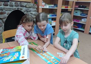 Trzy uczennice zajęć logopedycznych grają w grę „Drabina logopedyczna”.
