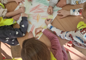 Przedszkolaki wykonują prace plastyczne oparte na jesiennych inspiracjach.