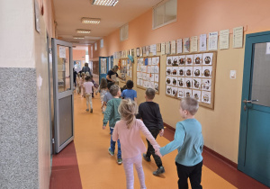 Przedszkolaki wędrują po szkole poznając jej najciekawsze miejsca.