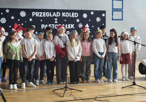 Dzieci z klasy 4c prezentują podczas szkolnego przeglądu pastorałkę „ Świeć gwiazdeczko mała świeć”.