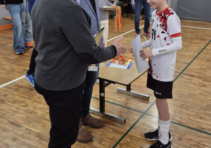 Kapitan zespołu odbiera pamiątkowy dyplom.