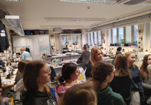 Uczestnicy wycieczki rozmawiają z pracownikami teatru w pracowni krawieckiej.