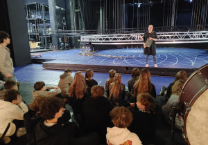 Oprowadzająca rozmawia z uczniami o specyfice pracy w Teatrze Wielkim.