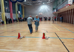 Uczestnicy zabawy biegną z piłka umieszczona na rakietce do tenisa stołowego.