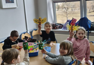 Dzieci prezentują wykonane własnoręcznie prace plastyczne.