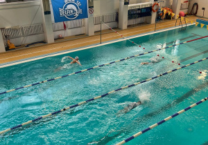 Uczniowie prezentują swoje umiejętności pływackie.