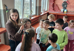 Uczniowie biorą udział w zabawie terenowej, podążając po szkole za wskazówkami.