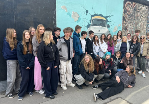 Zdjęcie uczestników wycieczki do Berlina na East Side Gallery przy najdłuższym zachowanym fragmencie Muru Berlińskiego.