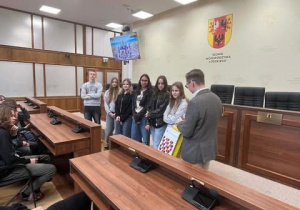 Grupa uczniów odbiera nagrody od pracownika Kancelarii Sejmiku.