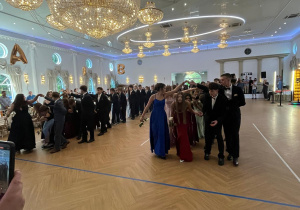 Uczniowie klas ósmych tańczą Poloneza.