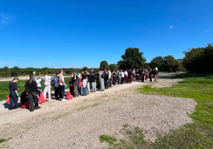Powrót na miejsce zbiórki. Uczniowie niosą zebrane śmieci.