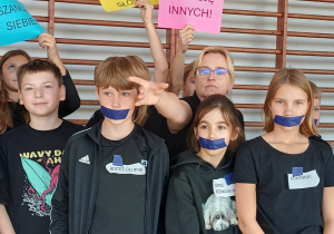 Uczniowie z klasy 4a prezentują plakaty dotyczące przeciwdziałaniu przemocy rówieśniczej.