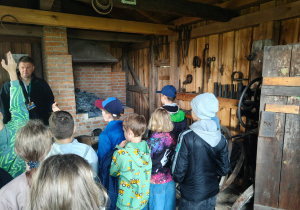 Uczniowie zwiedzają skansen - oglądają kuźnię