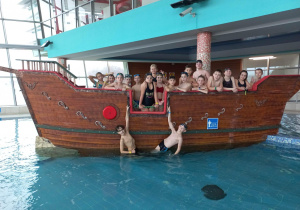 Grupa chłopców stoi na statku pirackim znajdującym się w jednym z basenów wewnętrznych