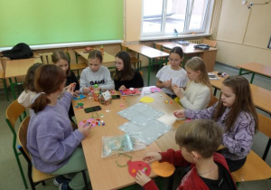 Uczniowie wykonują papierowe bombki podczas zajęć z języka polskiego odbywających się na terenie szkoły