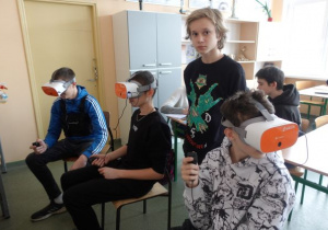 Uczniowie oglądają przez okulary VR kosmos i lądowanie człowieka na księżycu
