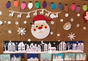 Zimowe i świąteczne inspiracje plastyczne zamieszczone na tablicy znajdującej się na szkolnym korytarzu. Prace wykonane przez uczniów klas 1-5
