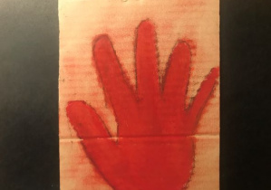 Na grubej tekturce zabarwionej w ciepłej tonacji uczeń przedstawił dłoń symbolizującą najstarsze podpisy na świecie
