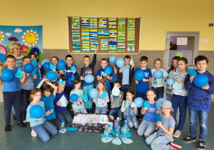 Uczniowie klasy 2b prezentują swój plakat z okazji dnia Święta Wody trzymając w dłoniach niebieskie balony