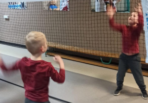 Zabawy sportowe z udziałem najmłodszych gości na szkolnym korytarzu