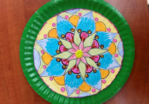 Mandala przygotowana na papierowym talerzyku. Główne motywy zaplanowane zostały w barwach zimnych. Praca wykonana przez Zosię. Klasa 5d